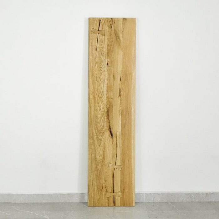 Bordsskiva-Antique-2-Grundoljad-8.jpg Träskiva med fjärilsförband på vit vägg.