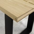 Närbild av träbordsskiva med metallben.