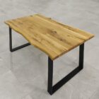 Rustik träbord med metallben på grått golv.