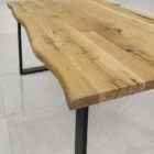 Rustikt träbord med svart metallben.