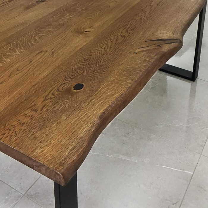 Bordsskiva-Live-Edge-1-Grundoljad-Brun3.jpg Rustikt träbord med metallben på stenplattor.