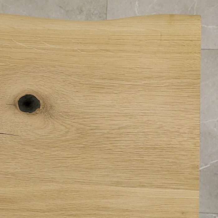 Bordsskiva-Live-Edge-1-Obehandlad7.jpg Närbild av träskiva med kvist.