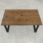 Rektangulärt träbord med svarta ben.