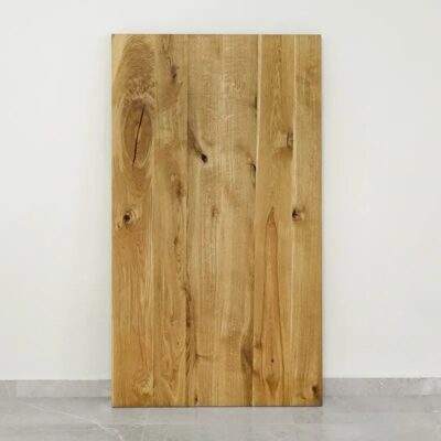 Träplanka stående mot vit vägg.