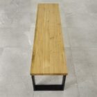 Träbänk på grått kakelgolv.