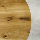 Runt träbord mot ljus stengolv.