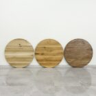 Tre runda träskivor mot vit vägg.