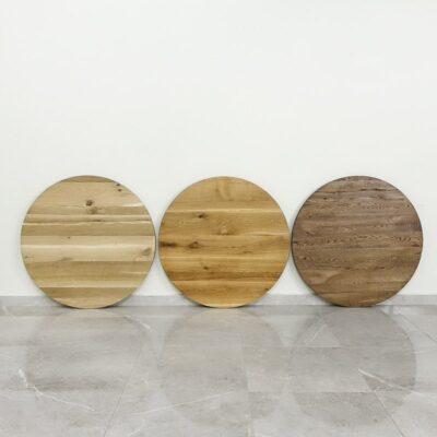 Tre runda träskivor mot vit vägg.