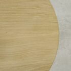 Rund bordsskiva av trä på marmorgolv.