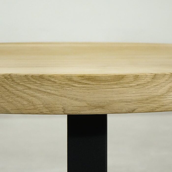 Bordsskiva-Round-60-cm-Grundoljda-obehandald4.jpg Närbild av träbordsskiva med svart ben.