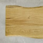 Träbord med naturligt formsnitt på stengolv.