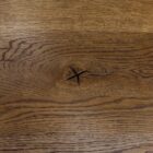 Brun träyta med tydlig ådring och kvistmärke.