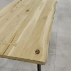 Träbord med naturkant på stengolv.