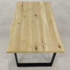 Träbord med metallben på stengolv.