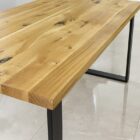 Träbord med metallben på kakelgolv.