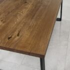 Träbord med svarta metallben på kakelgolv.