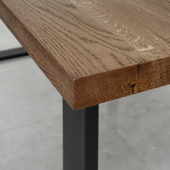 Bordsskiva-Strong-1-Grundoljad-Brun4.jpg Nära av ett träbordshörn på metallben.