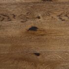 Brun träyta med synliga ådringar och kvistar.