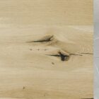 Närbild av träyta med ådring och sprickor.