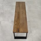 Träbänk på grått klinkergolv.