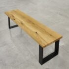 Träbänk på stengolv med metallben.