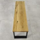 Träbänk på ljusgrått kakelgolv.