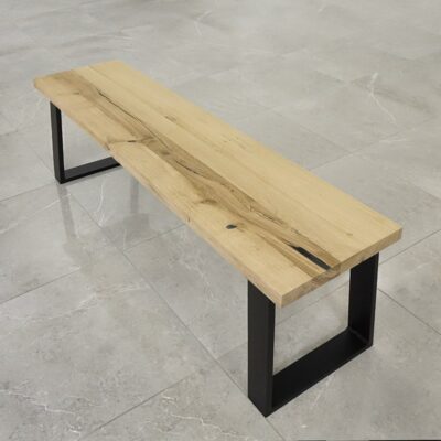 Träbänk med metallben på stengolv.