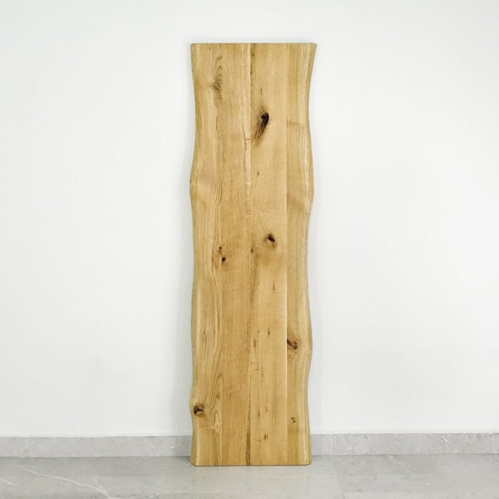 Bordsskiva-Wood-1-Grundoljad10.jpg Träskiva med naturlig kant mot vit vägg.