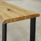 Träbord med svarta metallben på kaklat golv.