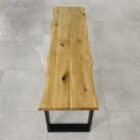 Träbänk med stålben på kakelgolv.