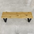 Träbänk med metallben på kaklat golv.