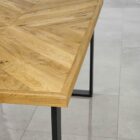 Närbild av ett träbord med metallben.