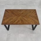 Träbord med fiskbensmönster och metallben.