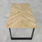 Träbord med fiskbensmönster och metallben.