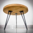 Runt träbord med svarta metallben.