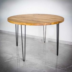 Runt träbord med metallben på stengolv.