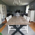 Rustikt matbord med stolar och ljuskrona ovan.