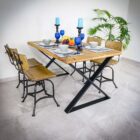 Rustikt matbord med stolar och ljusblå dekorationer.