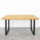 Träbord med svarta metallben på grått golv.