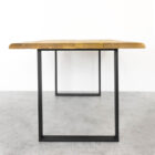 Träbord med metallben på grått golv.