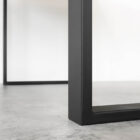 Svart metallbordben på betonggolv