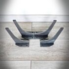 Fyra svarta metallkonsoler på trägolv.