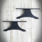 Två svarta hyllor mot trägolv.