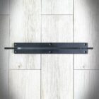 Svart dörrbult på trägolv