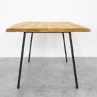 Träbord med metallben på grått golv.
