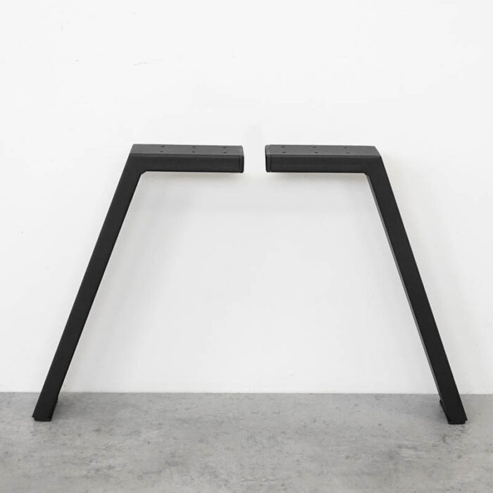 Platt-31-60x2012-1.jpg Två svarta bordsben mot vit vägg.