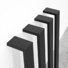 Svarta metallben mot vit vägg på rad