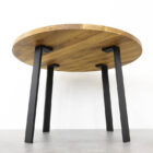 Runt träbord med svarta metallben.