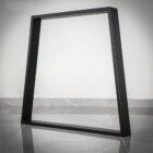 Svart metallram mot en vit vägg.