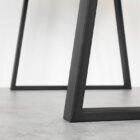 Svart metallbordben på grå golvyta.